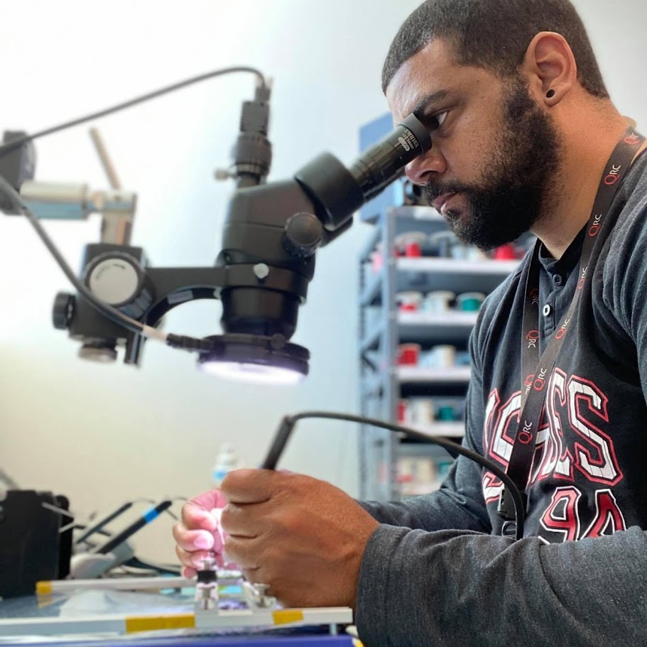 Luis (Tito) Santa soldering a device circuit board at Your Tech Tito
